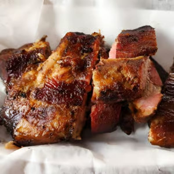 Close-up of Hank's Catfish & BBQ's juicy, dark brown smoked brisket pieces with pink smoke rings.