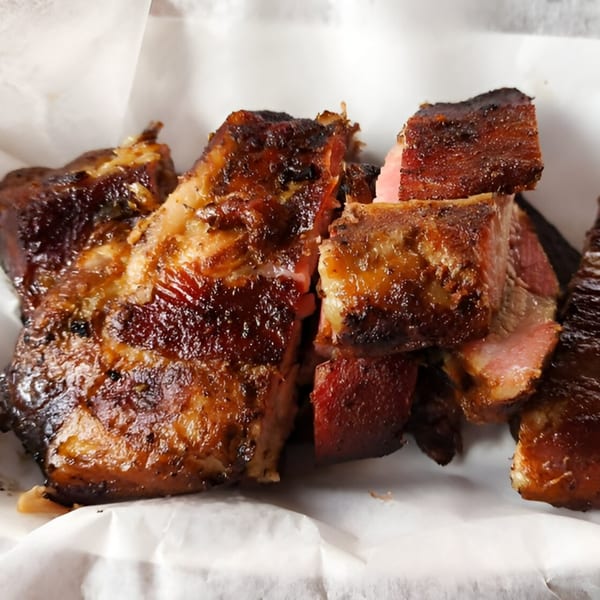 Close-up of Hank's Catfish & BBQ's glistening, dark brown, chopped BBQ ribs with pink smoke rings.