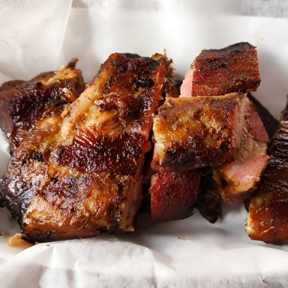 Close-up of Hank's Catfish & BBQ's glistening, dark brown, chopped BBQ ribs with pink smoke rings.
