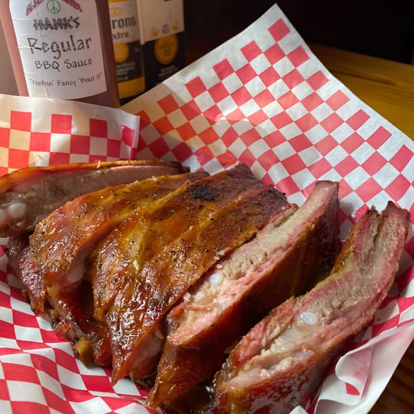 Hank's Catfish & BBQ ribs with sauce, served in a red and white checkered paper-lined basket.